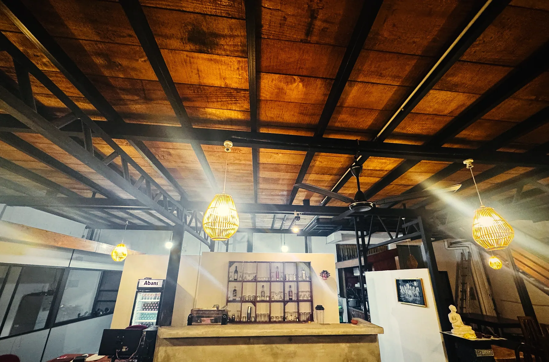 Woven gold lanterns glowing under the timber roof