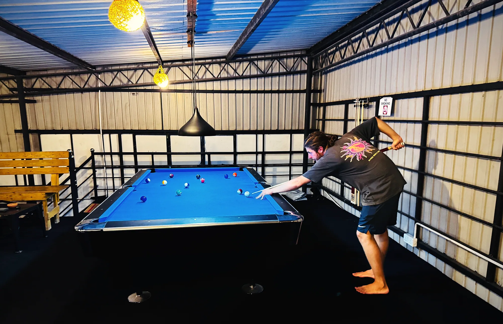 A guest lining up a shot on a blue pool table on Meyola's upper deck